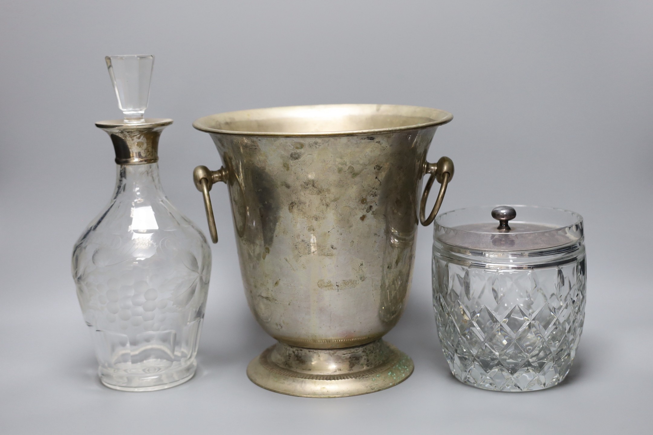 A silver plated wine cooler, a silver topped decanter and a silver lidded cut glass biscuit barrel